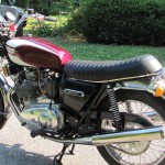Triumph Trident T160 - 1975 - Exhaust Silencer, Side Panel, Triumph Badge, Shock Absorber and Seat.