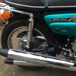 Suzuki GT750J - 1972 - Exhaust System, Swing Arm, Side Panel, Liquid Cooled Badge, Brake Cable and Lever.